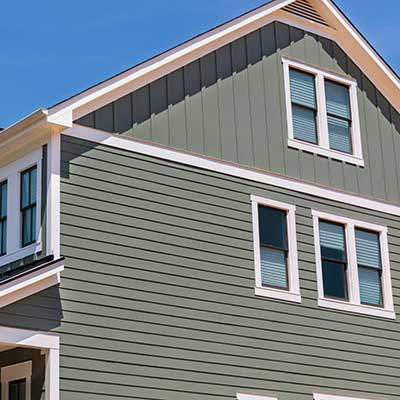 Side view and close up of a two-story home with green siding