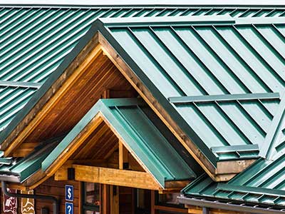 Close up of a green, sloped metal roof on a commercial building