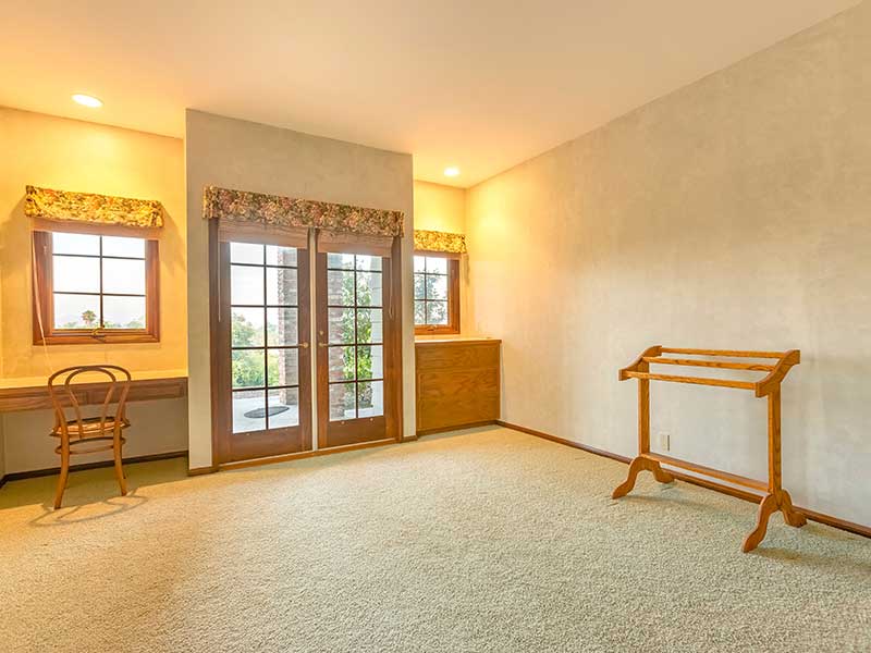 Newly added carpeted and empty room with double doors leading outside