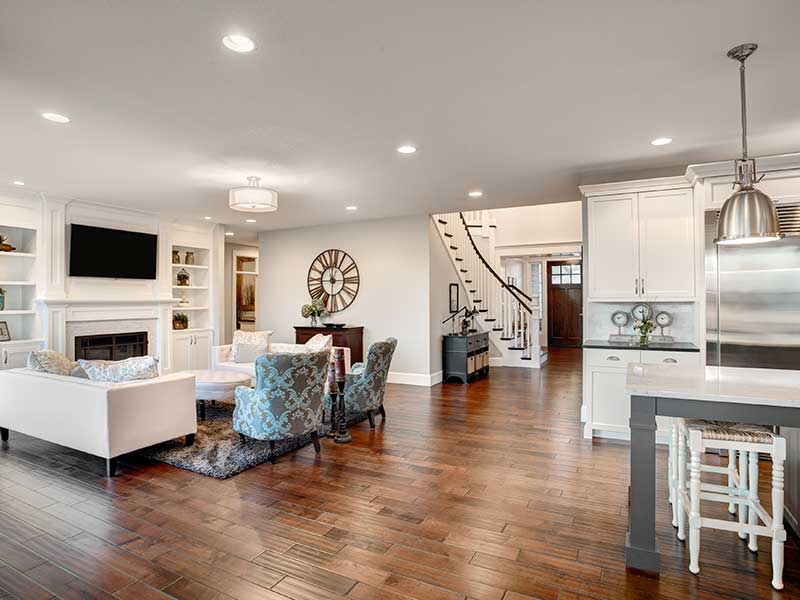 Modern living room, kitchen, and entrance area arranged in an open floor plan