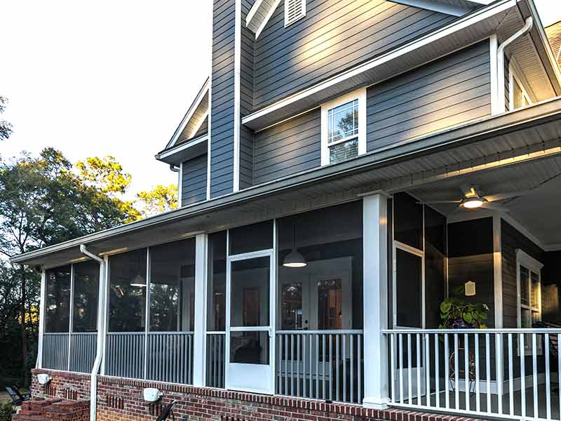 Side view of a large, two-story home with blue siding